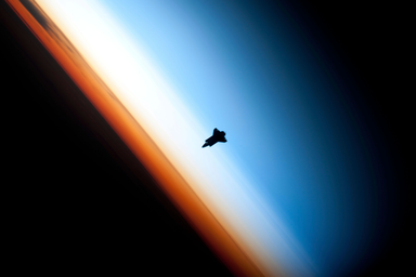 Silhouette of space shuttle Endeavour over Earth's colorful horizon (Copyright protected): Space shuttle is located in the ionosphere (deep buffer layer between the atmosphere and space) where the neutral air and plasma coexist.