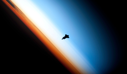 Silhouette of space shuttle Endeavour over Earth's colorful horizon (Copyright protected)